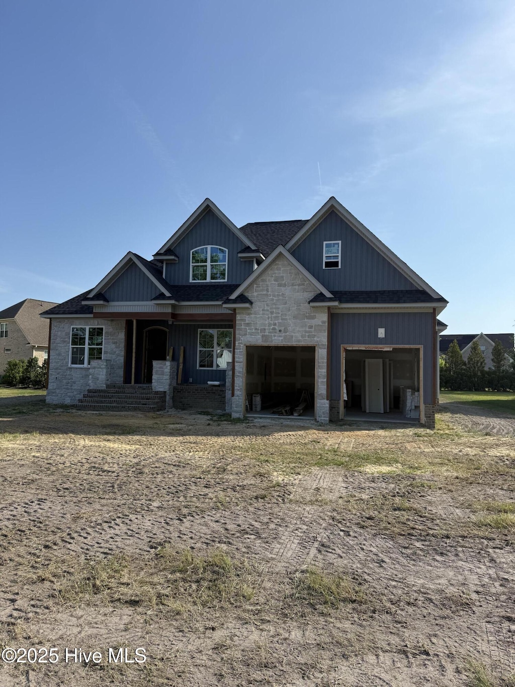 craftsman-style house featuring a garage, board and batten siding, and stone siding