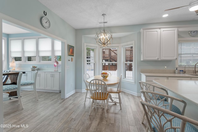 2403 W Oak Island Dr, Oak Island, NC 28465 - dining area with light wood-style flooring, a ceiling fan, and baseboards