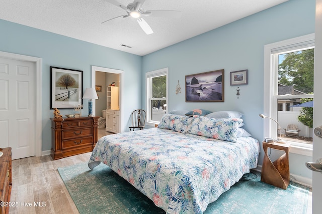 2403 W Oak Island Dr, Oak Island, NC 28465 - bedroom with light wood-style floors, a ceiling fan, and ensuite bathroom