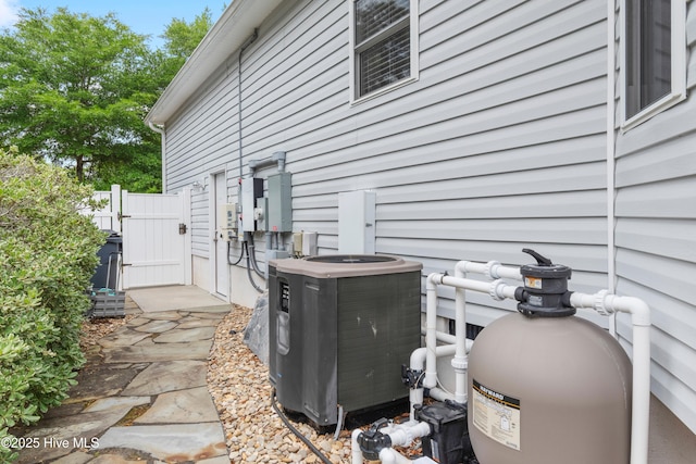2403 W Oak Island Dr, Oak Island, NC 28465 - exterior view of cooling unit, a gate, pump, and fence