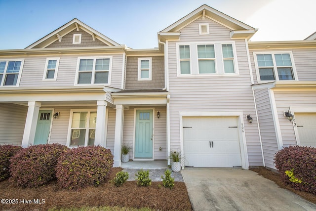 multi unit property featuring a garage and concrete driveway