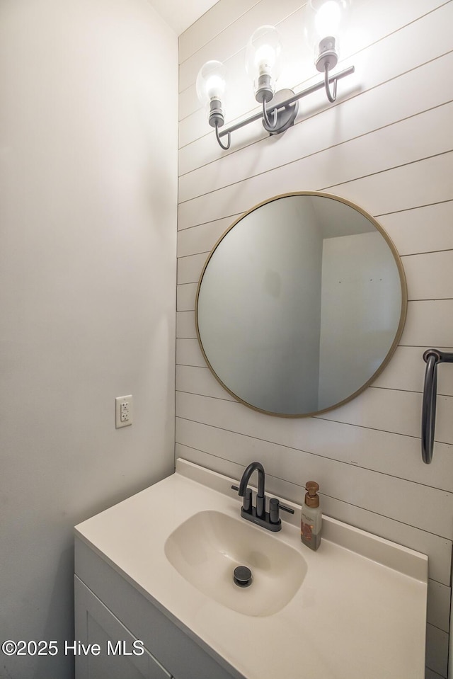 bathroom with vanity and wood walls
