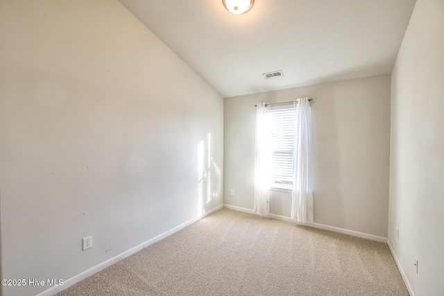 unfurnished room featuring baseboards, visible vents, light carpet, and lofted ceiling