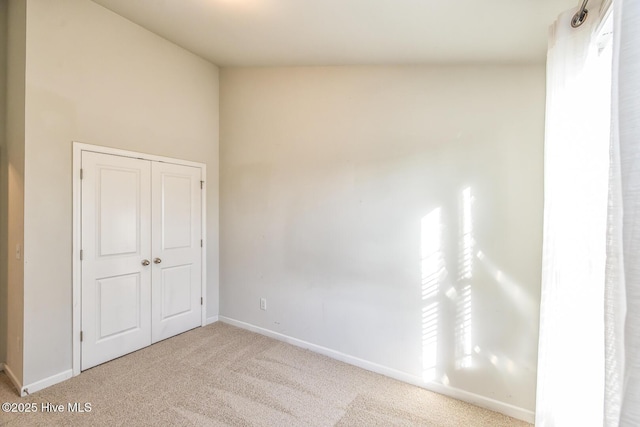 unfurnished room with carpet floors and baseboards