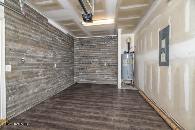 unfurnished room featuring electric panel, water heater, wood finished floors, and wooden walls