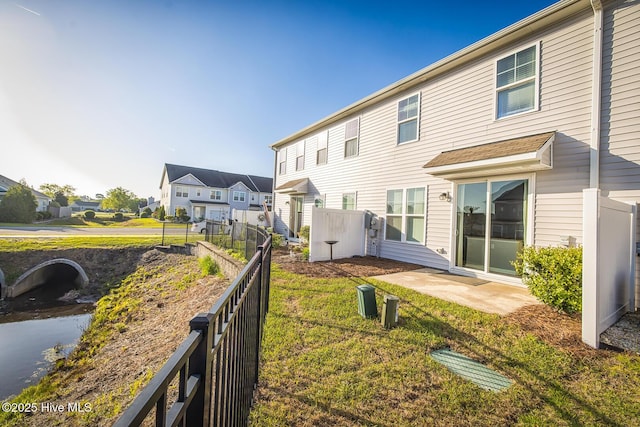 back of property featuring a patio, fence, a yard, and a residential view
