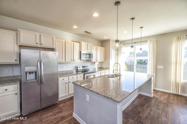 kitchen with light stone countertops, appliances with stainless steel finishes, a sink, visible vents, and dark wood-style floors
