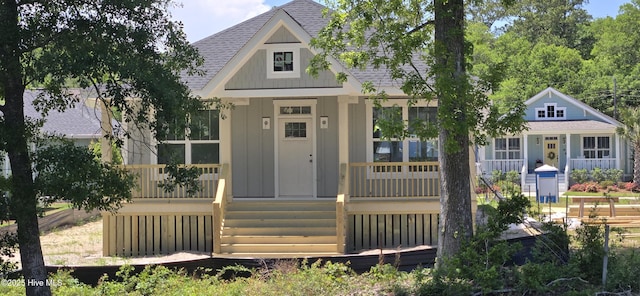1649 Butterfly Knot Dr SW, Ocean Isle Beach, NC 28469 - view of front of house with covered porch, board and batten siding, and a shingled roof