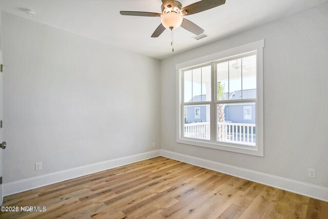 empty room with baseboards, visible vents, ceiling fan, and light wood-style floors