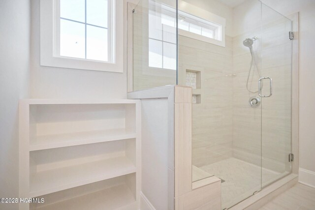 full bath with baseboards and a shower stall