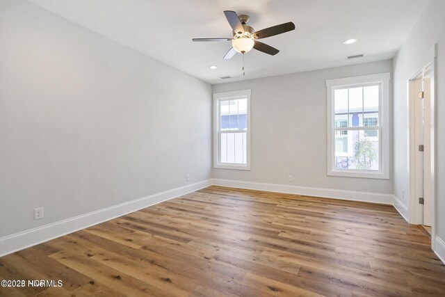 unfurnished room with visible vents, baseboards, ceiling fan, and wood finished floors