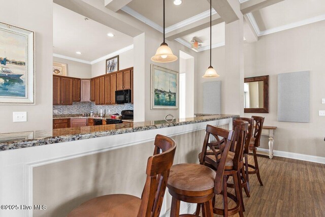 1649 Butterfly Knot Dr SW, Ocean Isle Beach, NC 28469 - kitchen featuring crown molding, baseboards, black appliances, and dark stone countertops