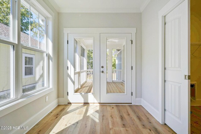 doorway to outside with crown molding, baseboards, and wood finished floors