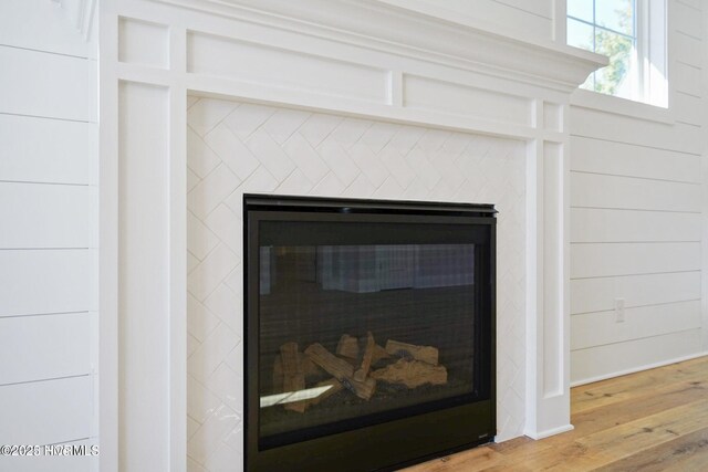 details featuring wood finished floors and a high end fireplace