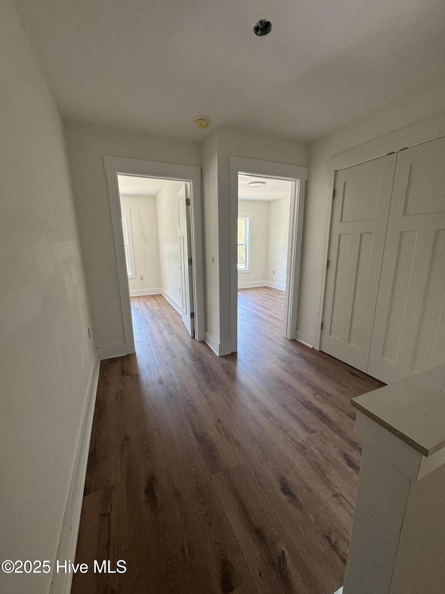 interior space with baseboards and dark wood-style flooring