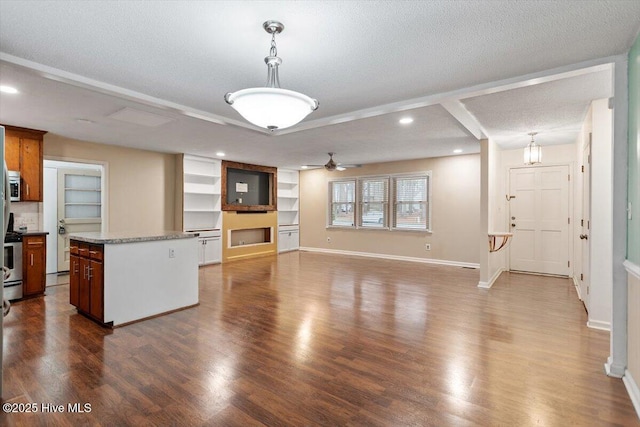 kitchen with dark wood-style flooring, a textured ceiling, pendant lighting, a center island, and recessed lighting