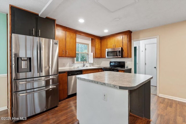 kitchen with a kitchen island, brown cabinets, dark wood finished floors, a sink, and stainless steel appliances