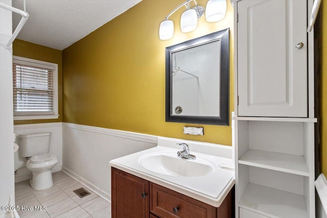 bathroom featuring a textured ceiling, visible vents, tile patterned flooring, vanity, and toilet