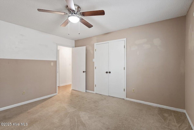 unfurnished bedroom with carpet flooring, baseboards, ceiling fan, and a closet