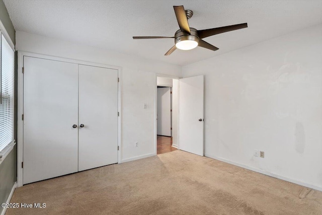 unfurnished bedroom with a closet, baseboards, ceiling fan, and carpet flooring