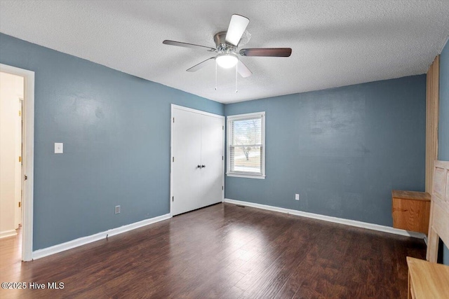 unfurnished bedroom featuring baseboards, a textured ceiling, ceiling fan, and wood finished floors