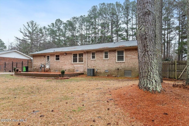 rear view of house featuring brick siding, central AC unit, fence, and crawl space