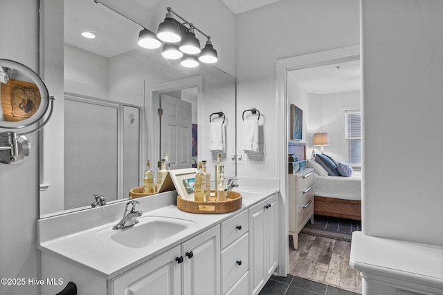 bathroom with a shower stall, ensuite bathroom, tile patterned flooring, and double vanity