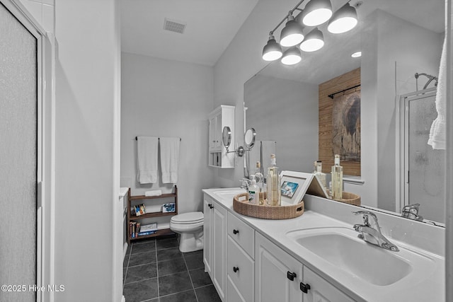 full bath featuring a stall shower, tile patterned floors, toilet, and double vanity