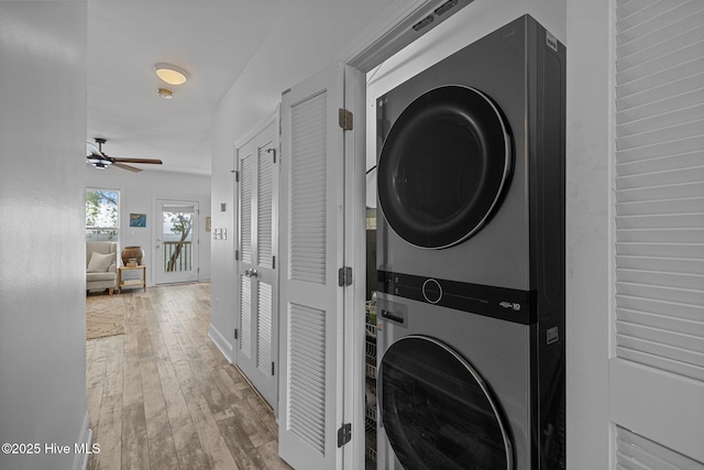 laundry area with stacked washer and clothes dryer, wood-type flooring, and a ceiling fan