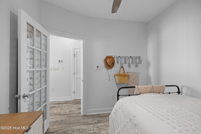 bedroom featuring light wood finished floors, baseboards, and a ceiling fan
