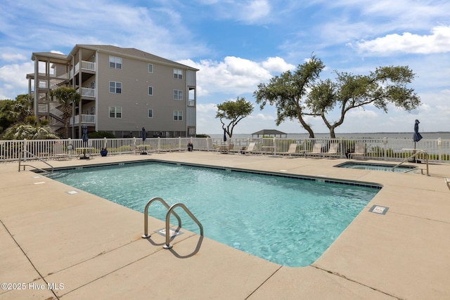 community pool with fence and a patio area