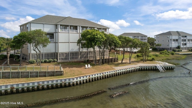 back of house with a water view and fence