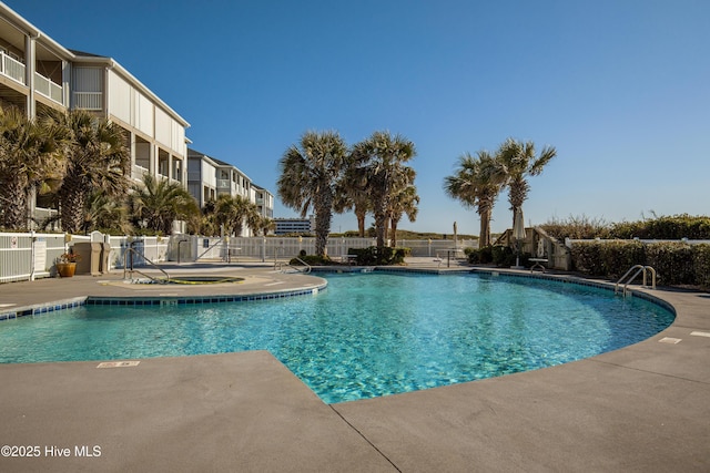 community pool with fence and a patio