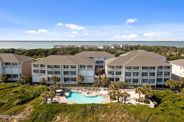 community pool featuring a water view and a hot tub