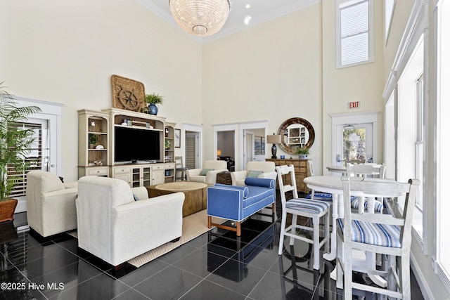 living area featuring a towering ceiling, crown molding, and healthy amount of natural light