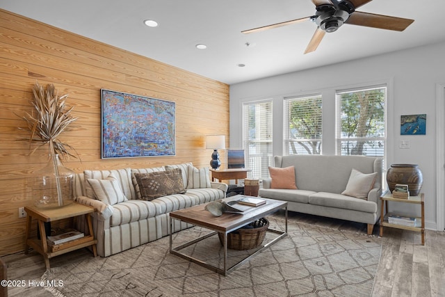 living room with wood walls, wood finished floors, recessed lighting, and a ceiling fan