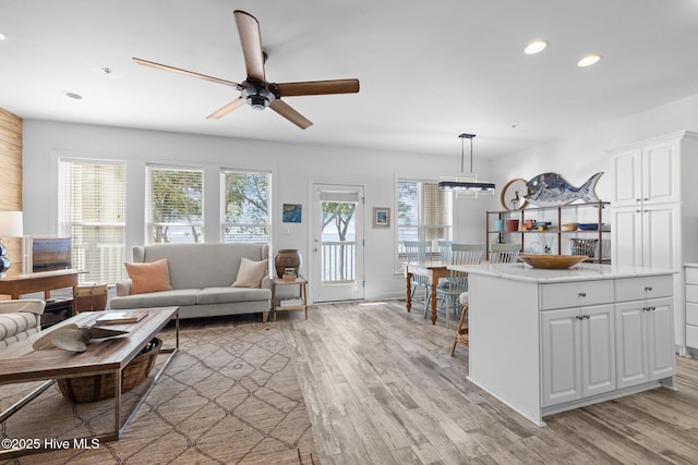 living area featuring recessed lighting, light wood finished floors, ceiling fan, and baseboards