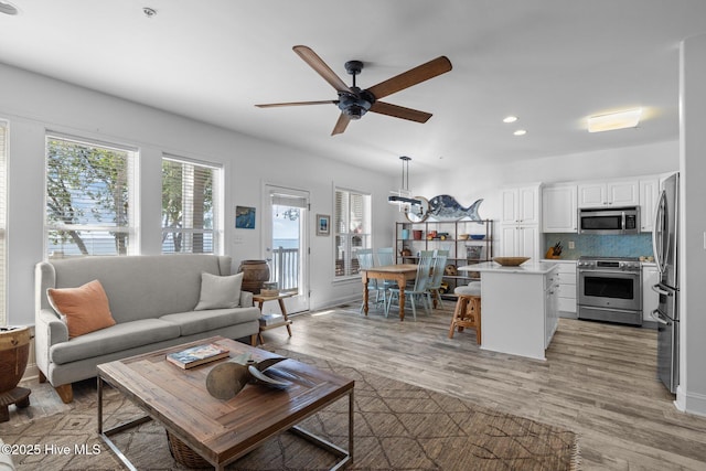 living area featuring recessed lighting, a ceiling fan, and light wood-type flooring