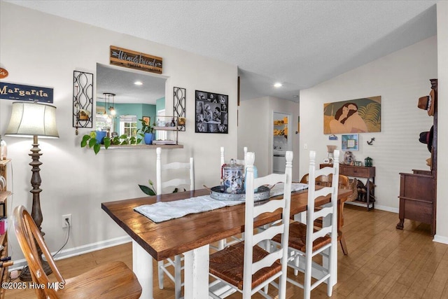 dining space with baseboards, recessed lighting, a textured ceiling, and wood finished floors
