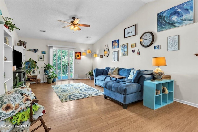 living area with visible vents, baseboards, ceiling fan, and wood finished floors