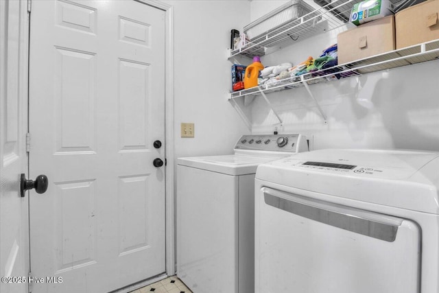 clothes washing area featuring laundry area and washer and clothes dryer