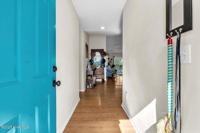 corridor featuring recessed lighting, baseboards, and wood finished floors