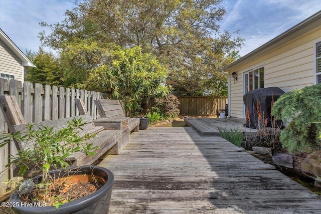 deck with a fenced backyard and a grill