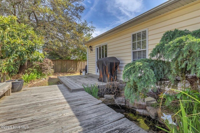 wooden deck with a fenced backyard