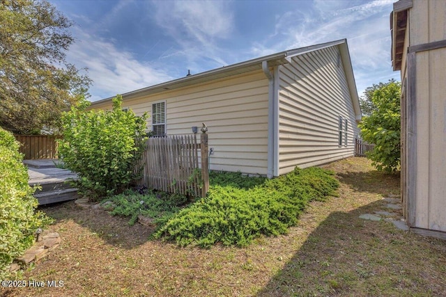 view of home's exterior featuring a deck and fence