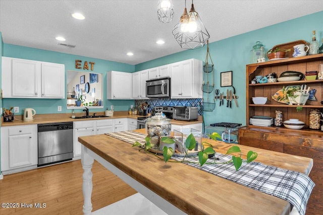 kitchen featuring a sink, white cabinetry, appliances with stainless steel finishes, and a textured ceiling