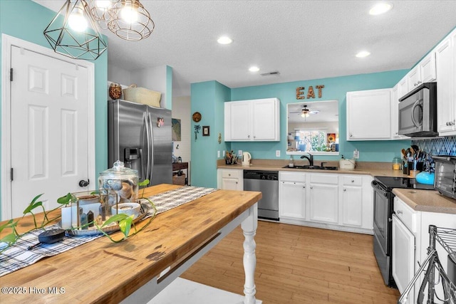 kitchen featuring light countertops, white cabinetry, appliances with stainless steel finishes, and a sink