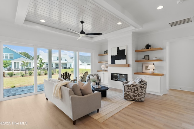 316 Lightning Bug Ln, Holly Ridge, NC 28445 - living room with visible vents, light wood-style flooring, a raised ceiling, and a large fireplace