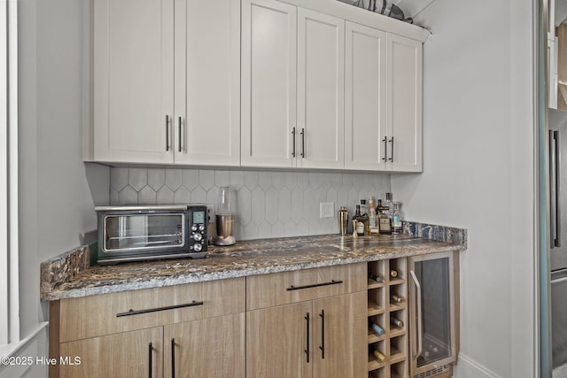 bar featuring a toaster, a dry bar, and backsplash