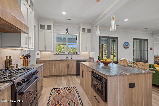 kitchen with light wood-style floors, decorative backsplash, appliances with stainless steel finishes, and custom exhaust hood